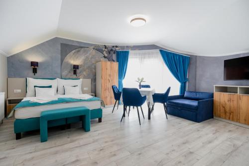 a bedroom with a bed and a table and chairs at Gasthaus Panzió in Szilvásvárad