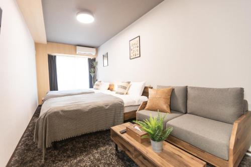 a living room with a bed and a couch at b&Namba 2 in Osaka