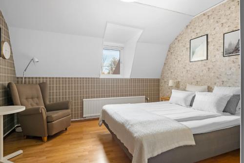 a bedroom with a large bed and a chair at Sure Hotel by Best Western Ojaby Herrgard in Växjö