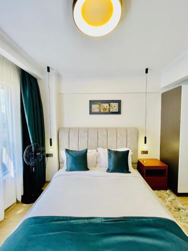 a bedroom with a large bed with blue pillows at Marina Bay Apartments Nairobi, Westlands in Nairobi