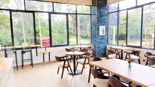 a restaurant with tables and chairs and windows at Marina Bay Apartments Nairobi, Westlands in Nairobi
