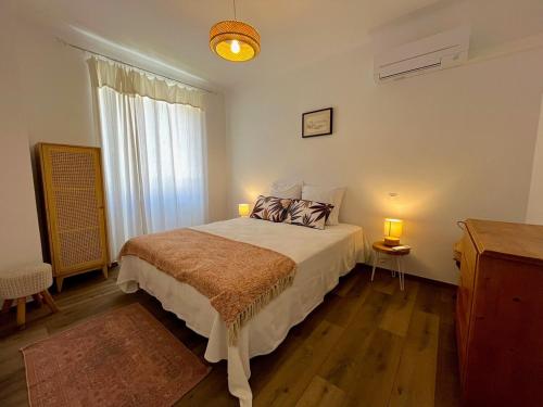 une chambre avec un lit avec deux lampes et une fenêtre dans l'établissement Charmant appartement 50 m Plage, à Ajaccio