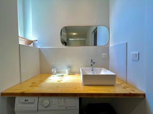 une salle de bain avec un lavabo blanc et un miroir dans l'établissement Charmant appartement 50 m Plage, à Ajaccio