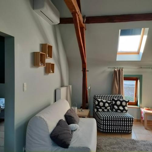 a living room with a couch and a chair at gite air pur in Roisin