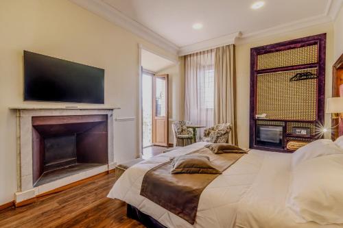 a bedroom with a bed with a fireplace and a flat screen tv at Villa Lecchi Hotel Wellness in Colle Val D'Elsa