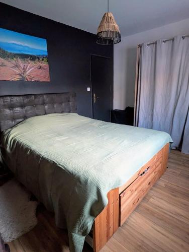 - une chambre avec un grand lit et un cadre en bois dans l'établissement Maison de vacances avec piscine, calme et confort, à Béziers