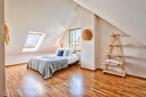 1 dormitorio con cama y escalera en Gîte La Ligne Bleue front de mer et vue sur une Tour Vauban, en Saint-Vaast-la-Hougue