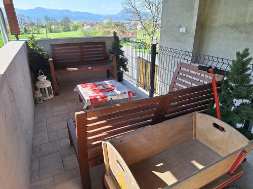 a balcony with two wooden benches and a table at Šipk -FREE-PARKING-BREAKFAST-TERRACE in Vojnik