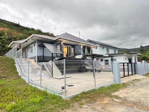 a house with a fence in front of it at Vinzsugudhomestay in Penampang