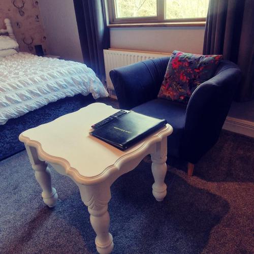a table with a laptop on top of it next to a chair at Church View House F56H977 in Gorteen