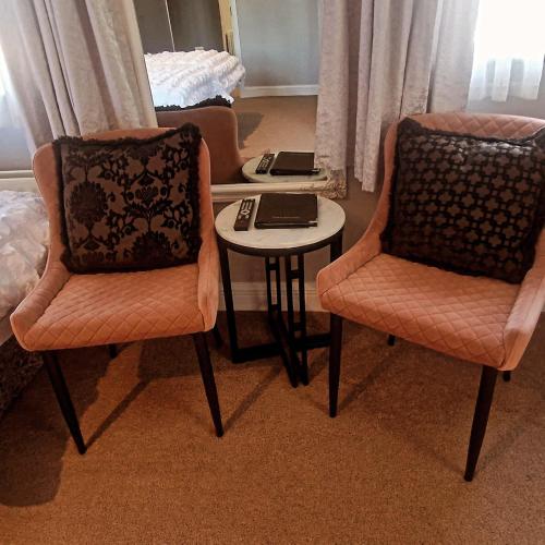 a room with two chairs and a table and a bed at Church View House F56H977 in Gorteen