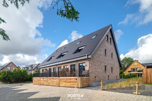 an old brick building with a black roof at Ferienwohung Genießen St Peter-Ording in Böhl