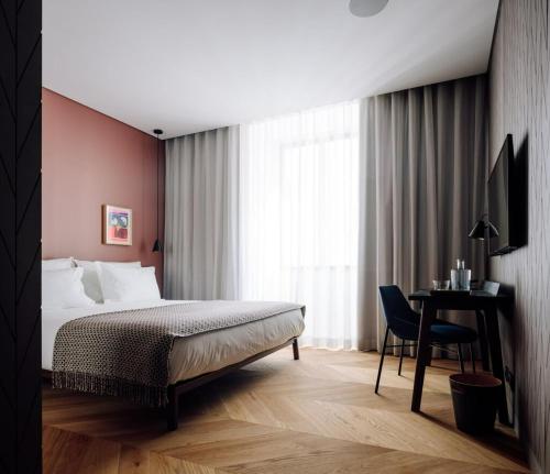 a bedroom with a bed and a desk and a window at Hotel Hotel - Member of Design Hotels in Lisbon