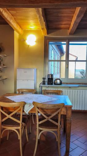 a dining room with a table and chairs and a kitchen at La Famulenta 17 in Grazzano Badoglio