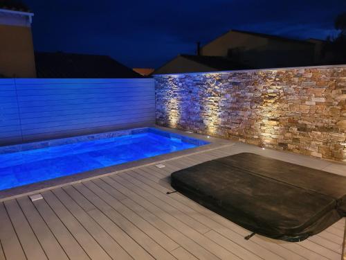 une piscine dans un jardin la nuit dans l'établissement Très belle villa a 100M de la plage, piscine , jacuzzi, terrasse en composite, à Sausset-les-Pins