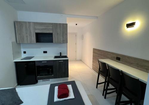 a kitchen with black appliances and a counter with chairs at Bayside A Apartments in St Julian's