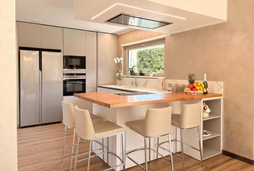 a kitchen with a kitchen island with chairs and a counter top at Serenity villa - Lake Como in Colico