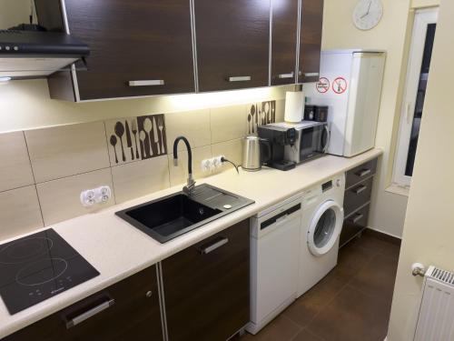a small kitchen with a sink and a microwave at Mały Domek na Starówce in Konin