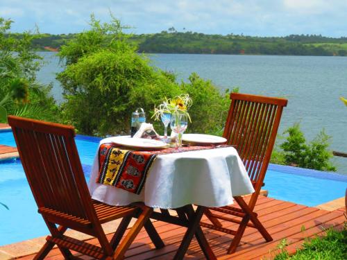 a table and two chairs with a table and water at Naara Eco Lodge & Spa in Chidenguele