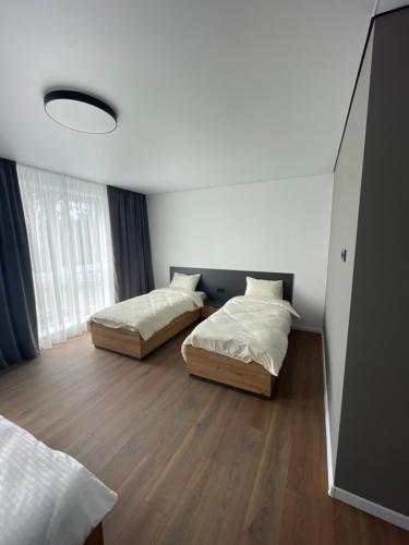 a bedroom with two beds and a large window at Hotel Hostel Перехрестя in Chistilov