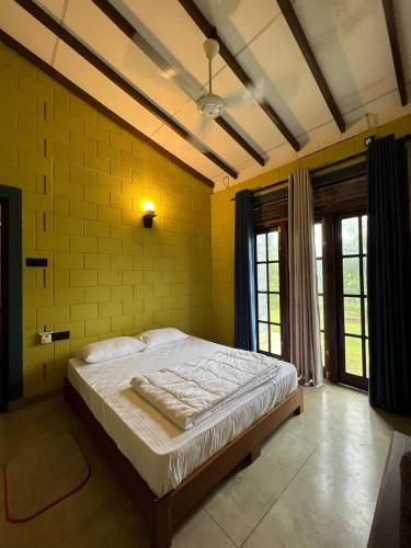 a bed in a room with a yellow wall at Lavender Villa by Kananke Hills in Kananke