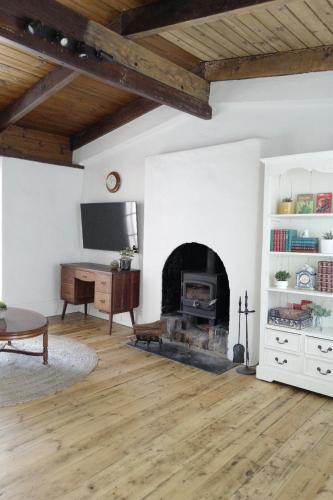 a living room with a fireplace and a desk at Charming Historical Cottage in Bridgewater in Bridgewater