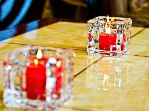 two candles sitting on top of a wooden table at Hotel Park Suites Chisinau in Chişinău