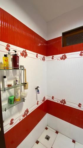 a bathroom with red and white walls and red accents at Coastal Lodge Bang saray in Bang Sare