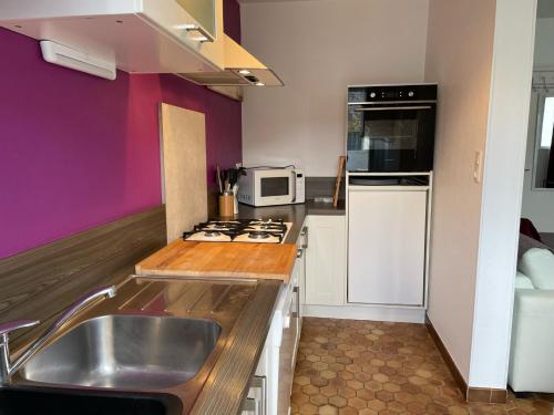 a kitchen with a sink and a stove top oven at Les Coquillages in Trégastel