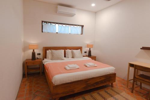 a bedroom with a bed with two towels on it at Hidden Mekong in Luang Prabang