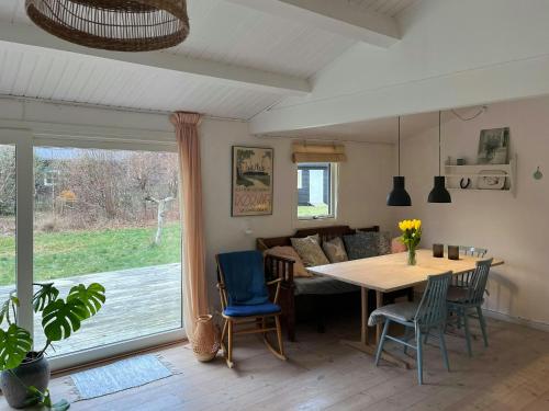 a dining room and living room with a table and chairs at Familiesommerhus Med Stor Terrasse I Rørvig in Rørvig
