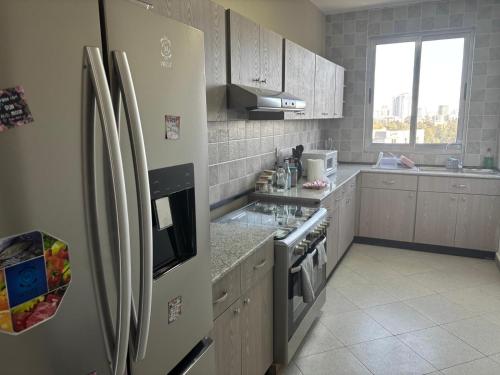 a kitchen with a refrigerator and a stove top oven at jambo apartment 4 in Addis Ababa