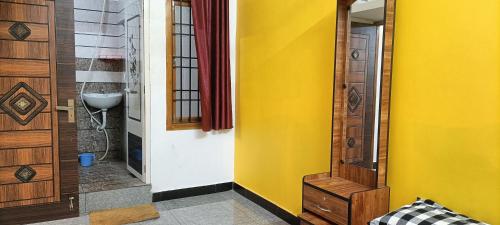 a hallway with a yellow wall and a door at NKS Service Apartment in Pondicherry