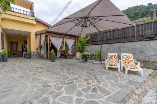 a patio with two chairs and an umbrella at Casa Federica in Ventimiglia