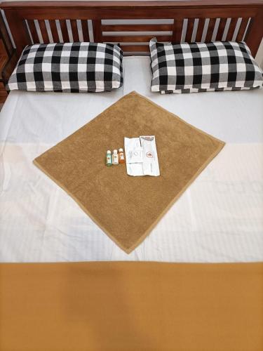 a bed with two pillows and a blanket on it at NKS Service Apartment in Pondicherry