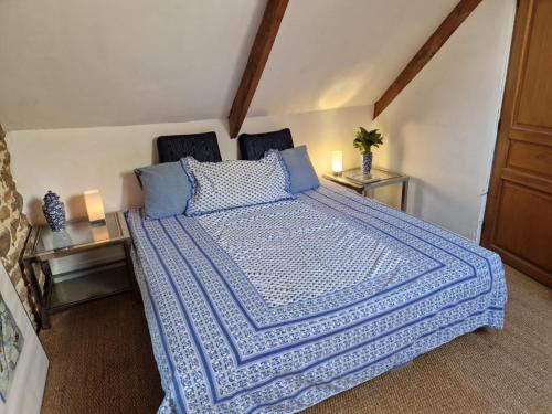 a bedroom with a large bed with a blue comforter at Gites Amorique Plesidy in Plésidy