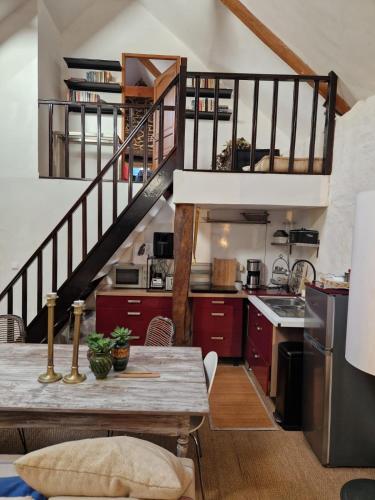 une cuisine avec des placards rouges et un escalier dans l'établissement Gites Amorique Plesidy, à Plésidy