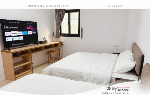 una camera da letto con due letti e una scrivania con televisione di 西衛參零陸民宿 Xiwei 306 Inn a Magong