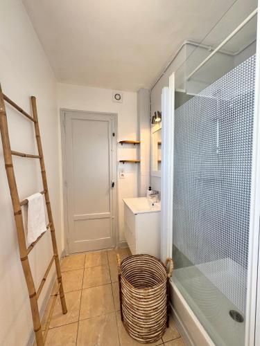 - une salle de bains pourvue d'une douche en verre et d'un panier dans l'établissement La Pilate, avec vue sur les toits de Rennes, à Saint-Jacques-de-la-Lande