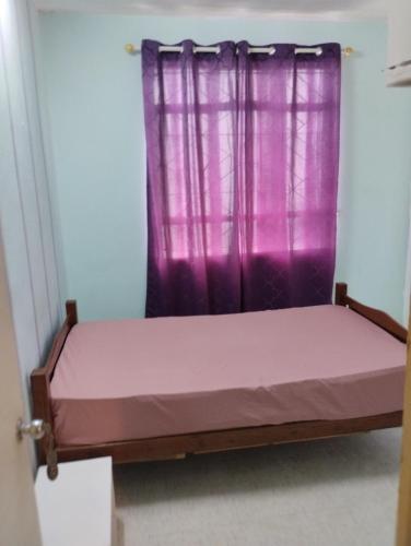 a bed in a room with a purple curtain at Apartment Les Tulipes in Richelieu Station