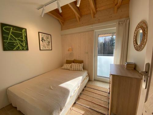 a small bedroom with a bed and a window at Choriatiki in Dębki