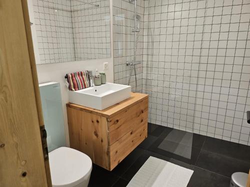 a bathroom with a white sink and a toilet at Ferienwohnung Schaivel in Müstair