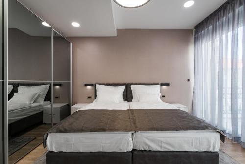 a bedroom with a large bed and a large window at Hotel - Teranea City Hvar in Hvar