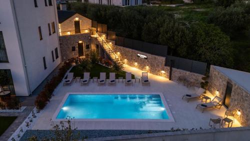 an overhead view of a swimming pool with chairs and a building at Villa Donatella in Podstrana