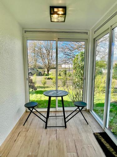 - une table et deux tabourets dans une pièce avec fenêtre dans l'établissement Appartement à 100m de la plage et Thalasso, à Concarneau