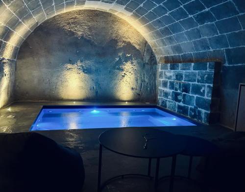 a hot tub in a brick tunnel with a table at Residence Masseria Santa Lucia in Matera