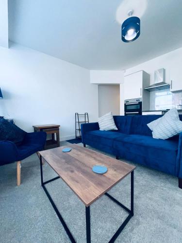 a living room with a blue couch and a table at The Corner house in Hartlepool