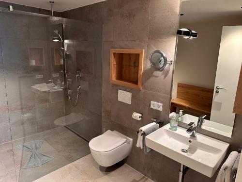 a bathroom with a shower and a toilet and a sink at Villa Alpjuwel in Oberstdorf