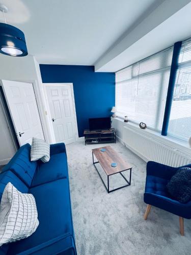 a living room with a blue couch and a coffee table at The Corner house in Hartlepool