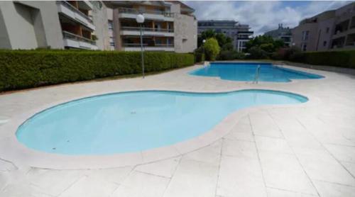une grande piscine bleue dans un immeuble dans l'établissement Toison avec piscine, à Dijon